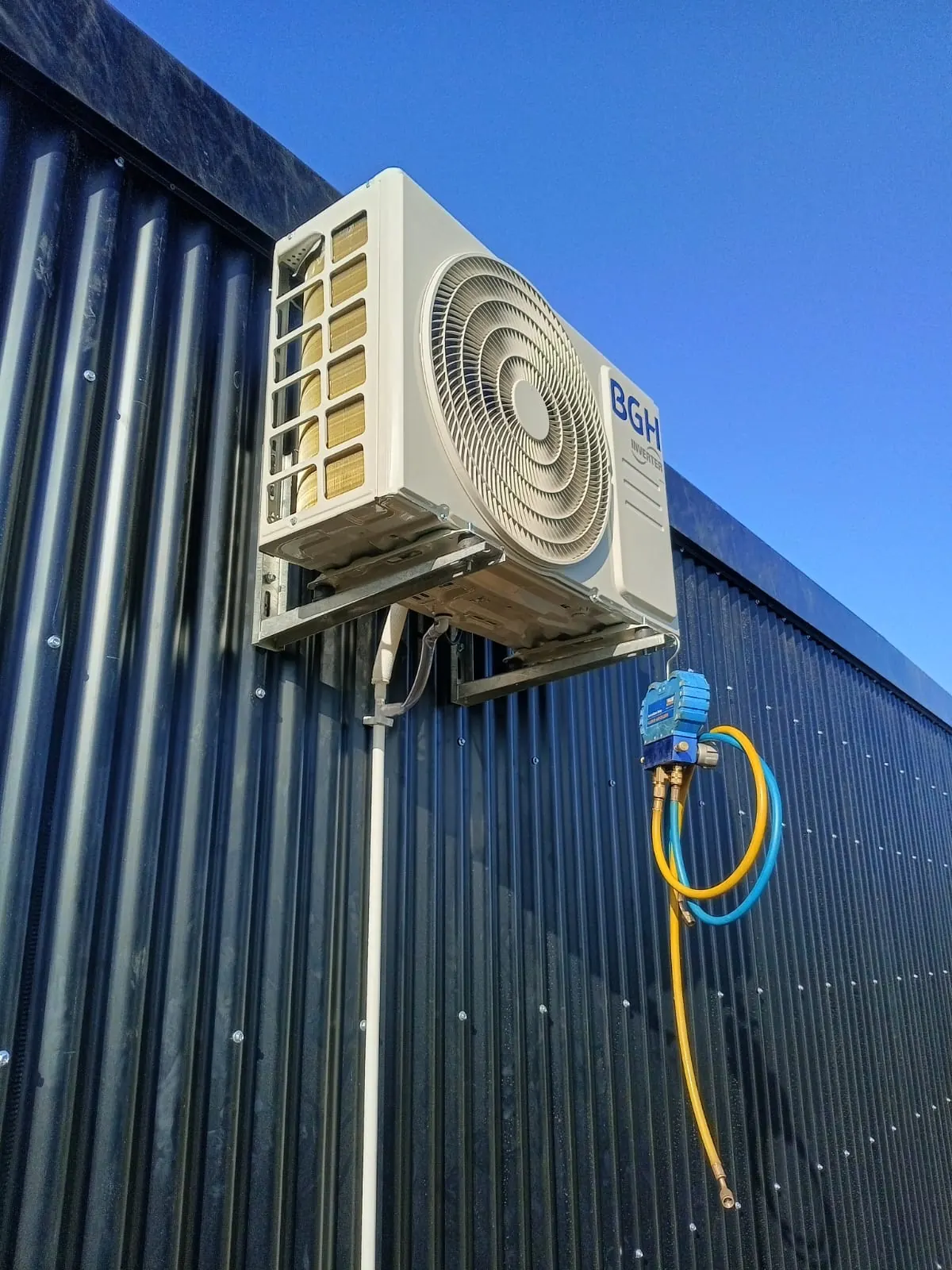 Unidad exterior BGH inverter en soporte de pared con manómetros conectados